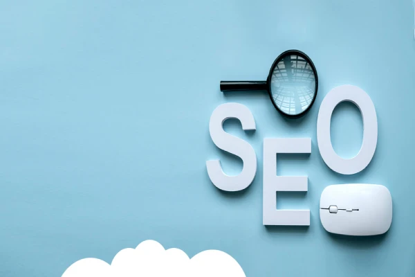 أدوات تسويق مُحسّن لمحركات البحث (SEO) على خلفية زرقاء. كُتب عليها "SEO" بأحرف بيضاء، بالإضافة إلى عدسة مكبرة وفأرة حاسوب. الكلمات مُكبّرة فوق أشكال بيضاء ناعمة.